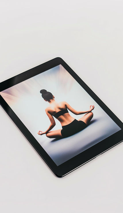 An Example product tablet rests on a white surface, showing a woman in workout clothes sitting cross-legged in a meditative yoga pose with her hands on her knees, viewed from behind.